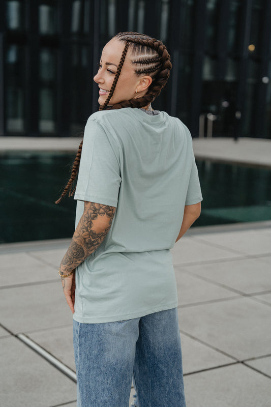 mintgrünes T-Shirt mit weißem Frontprint „perfectly imperfect“ in feiner, minimalistischer Typografie. Das T-Shirt besteht aus glattem Baumwollstoff und hat einen klassischen Rundhalsausschnitt sowie eine locker geschnittene Passform.