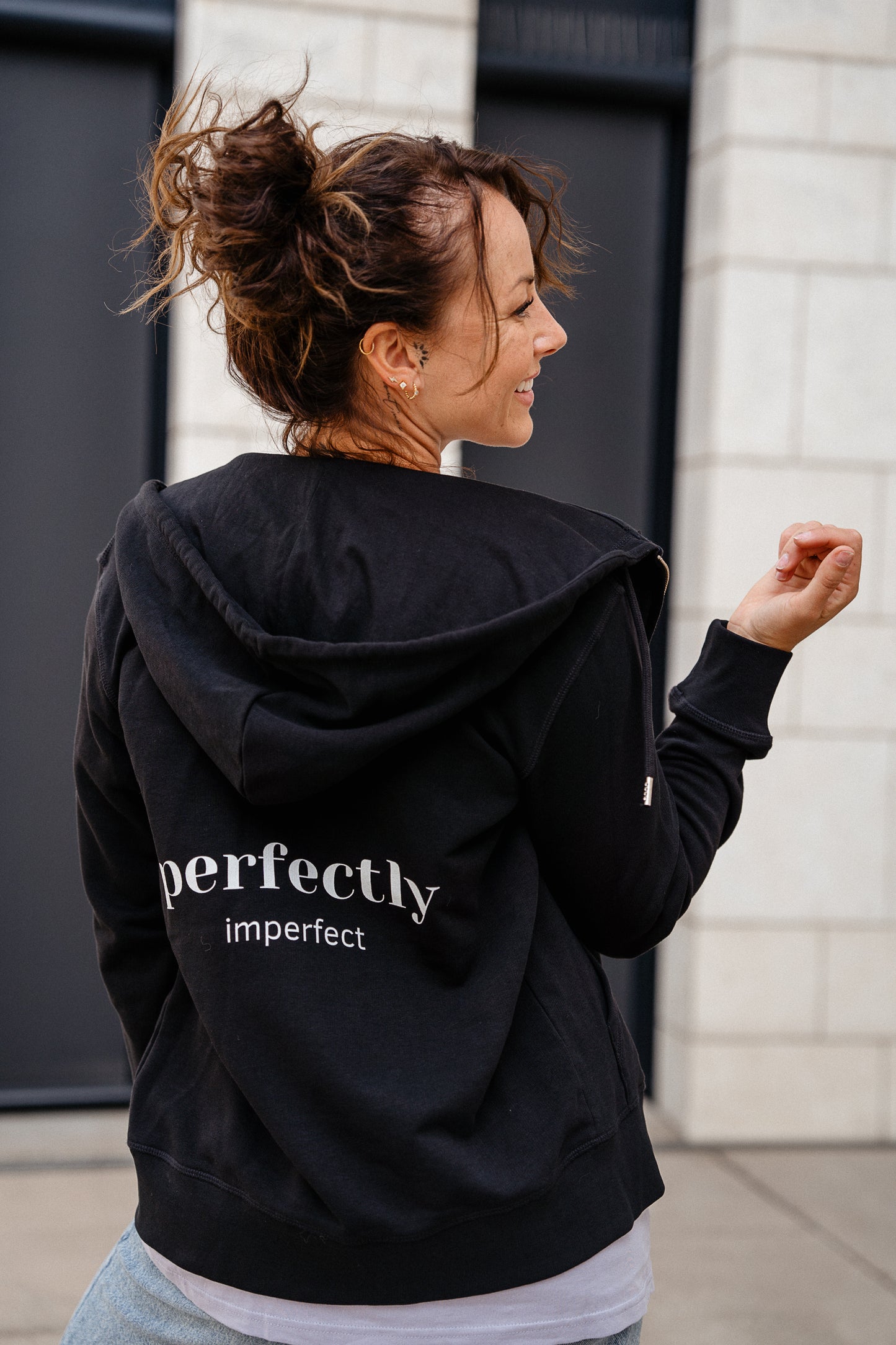 Schwarzer Kapuzenpullover mit Reißverschluss und großem weißem Rückendruck „perfectly imperfect“. Der Hoodie hat eine große Kapuze und eine lockere Passform.